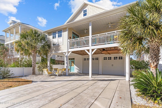 raised beach house featuring a patio, a balcony, a garage, and ceiling fan