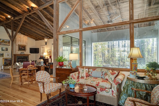 sunroom with wood ceiling, a large fireplace, and lofted ceiling with beams