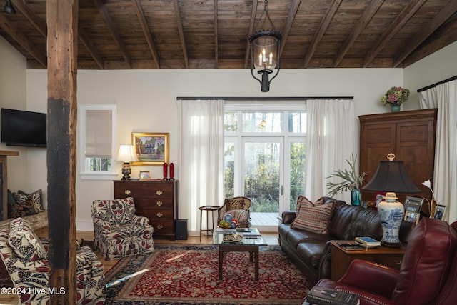 living room featuring beam ceiling, a healthy amount of sunlight, and wood ceiling