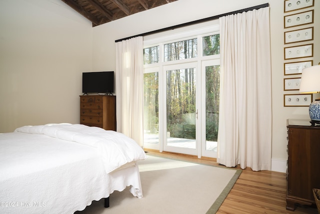 bedroom with access to outside, vaulted ceiling with beams, wood ceiling, and hardwood / wood-style flooring