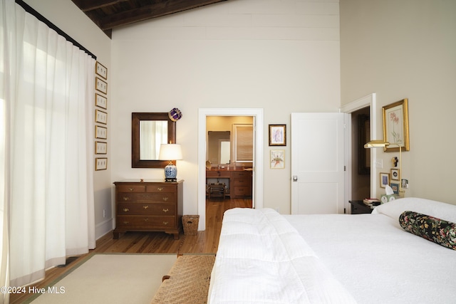 bedroom featuring beamed ceiling, wood-type flooring, high vaulted ceiling, and wooden ceiling