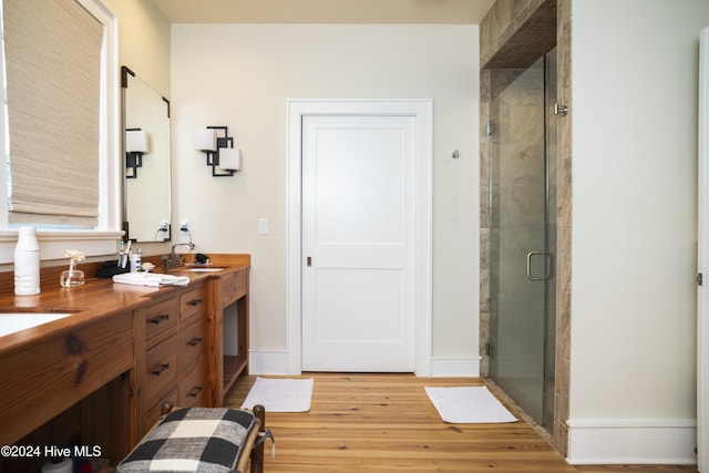 bathroom with a shower with door, vanity, and hardwood / wood-style flooring