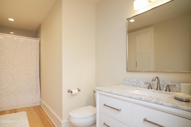 bathroom featuring vanity, wood-type flooring, and toilet