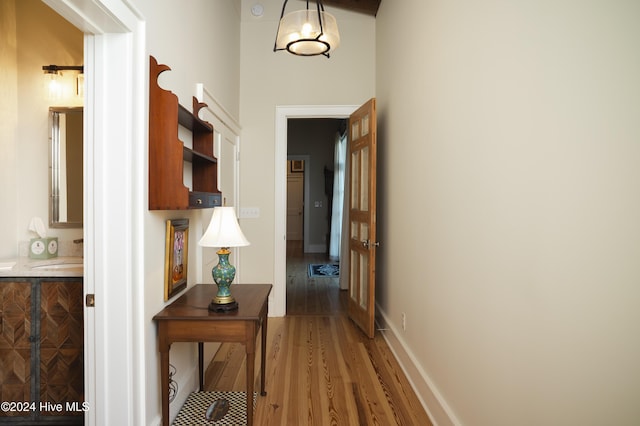 corridor with hardwood / wood-style floors and sink