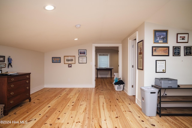 interior space featuring lofted ceiling and light hardwood / wood-style flooring