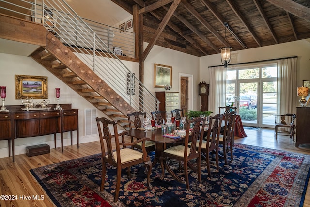 dining area featuring wood-type flooring, high vaulted ceiling, wood ceiling, and beam ceiling