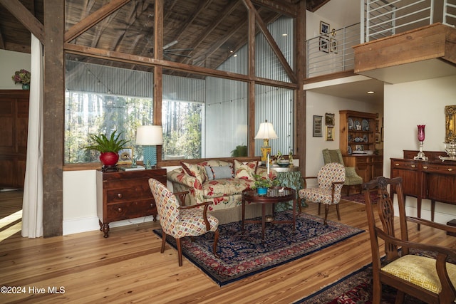 living room featuring beam ceiling, wood-type flooring, high vaulted ceiling, and wooden ceiling