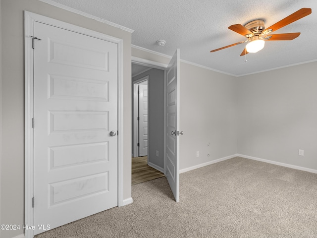 unfurnished bedroom with carpet flooring, crown molding, ceiling fan, and a textured ceiling