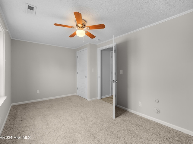 unfurnished bedroom with a textured ceiling, ceiling fan, ornamental molding, and light carpet