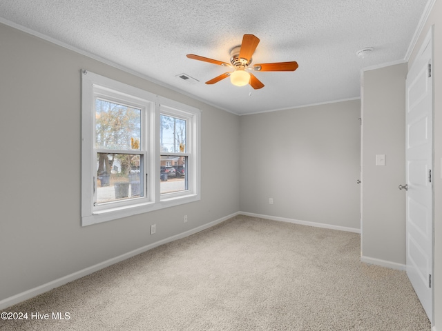 empty room featuring ceiling fan, crown molding, carpet floors, and a textured ceiling