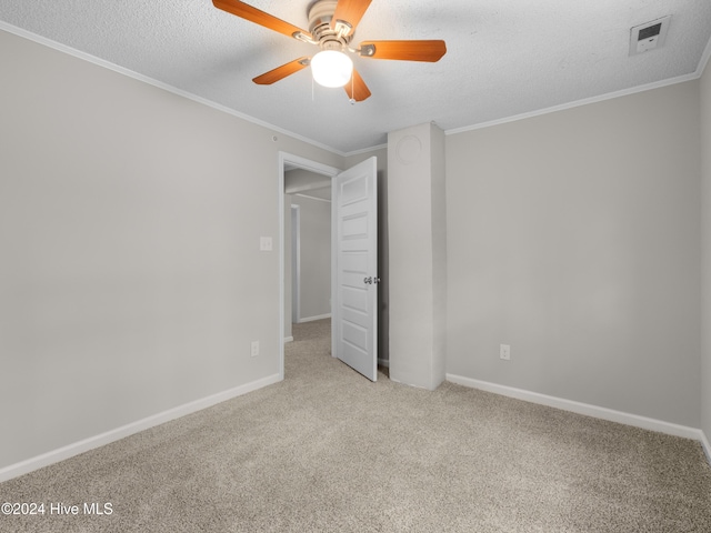 unfurnished bedroom with ceiling fan, crown molding, light colored carpet, and a textured ceiling