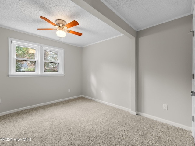 spare room featuring carpet flooring, a textured ceiling, ceiling fan, and crown molding