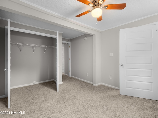 unfurnished bedroom with ceiling fan, a closet, light carpet, and ornamental molding