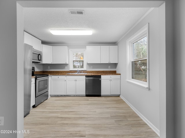 kitchen with white cabinetry, sink, stainless steel appliances, and a textured ceiling