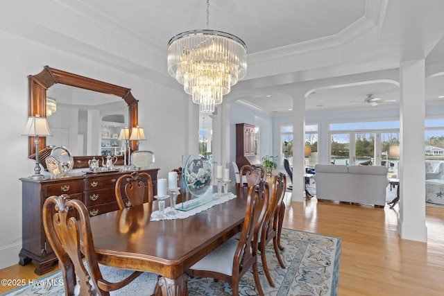 dining area featuring light wood-type flooring, crown molding, and ceiling fan with notable chandelier