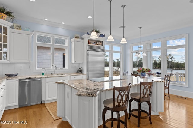 kitchen with tasteful backsplash, a center island, sink, white cabinetry, and stainless steel appliances