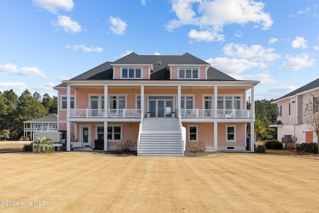 rear view of house featuring a lawn and covered porch