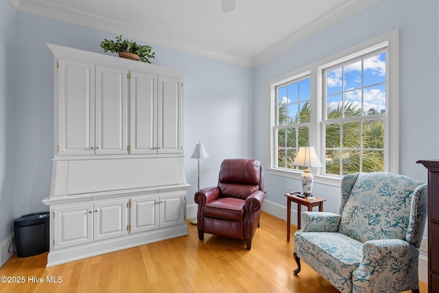 sitting room with crown molding and light hardwood / wood-style floors