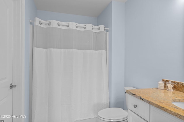 bathroom with toilet, vanity, and curtained shower