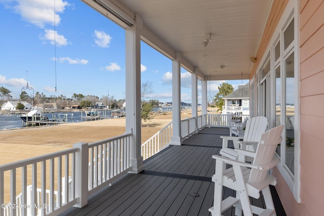 wooden deck with a water view and a porch