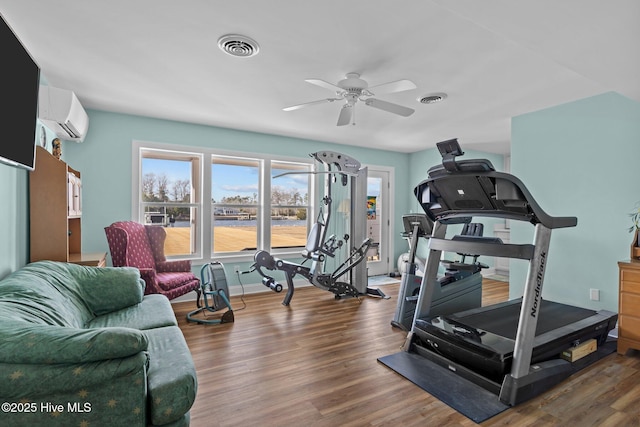 workout room featuring ceiling fan, a wall mounted AC, and dark hardwood / wood-style floors