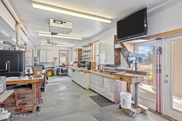 kitchen featuring ceiling fan and white cabinets