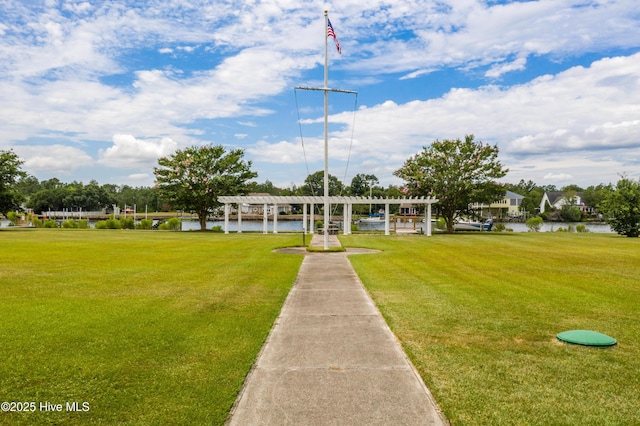 surrounding community featuring a water view, a pergola, and a yard