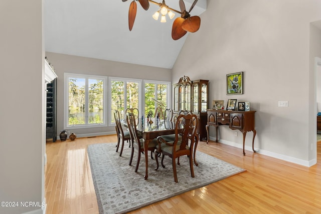 dining room featuring ceiling fan, wood-type flooring, and high vaulted ceiling