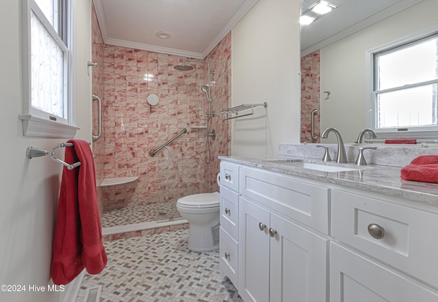 bathroom featuring toilet, vanity, ornamental molding, and tiled shower