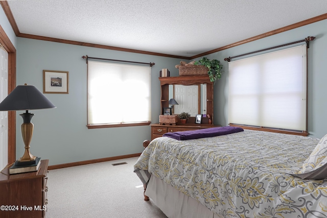 carpeted bedroom featuring ornamental molding and a textured ceiling