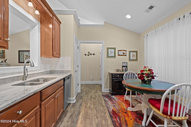 kitchen with lofted ceiling, sink, stainless steel dishwasher, dark hardwood / wood-style floors, and light stone countertops