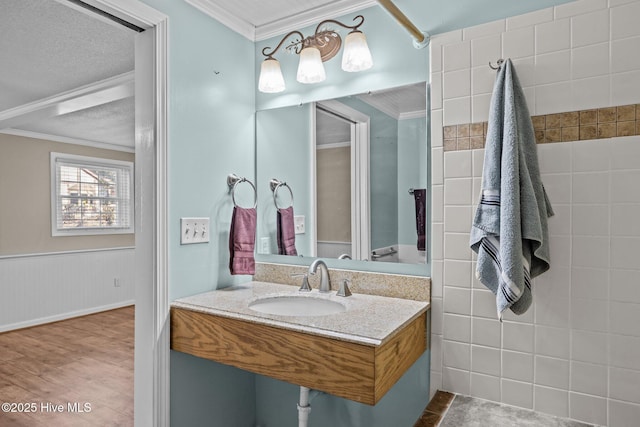 bathroom with sink, crown molding, and hardwood / wood-style flooring