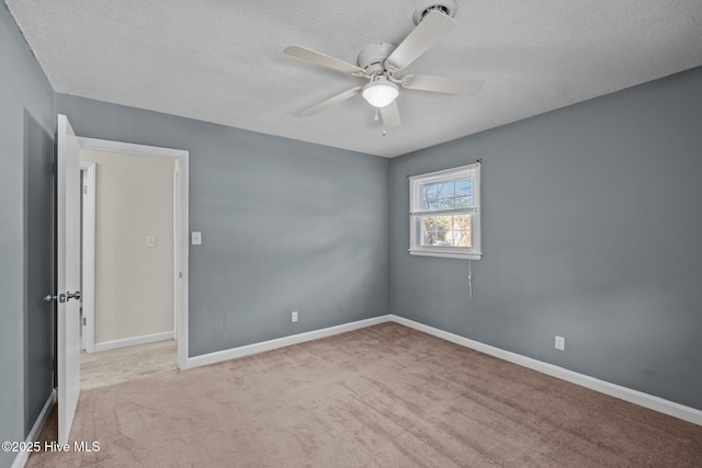 spare room with ceiling fan, light colored carpet, and a textured ceiling