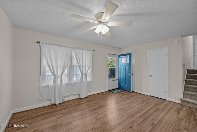 entryway featuring ceiling fan, a textured ceiling, and light hardwood / wood-style flooring