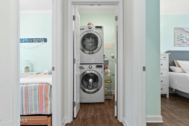 washroom with crown molding, dark hardwood / wood-style flooring, and stacked washer / dryer