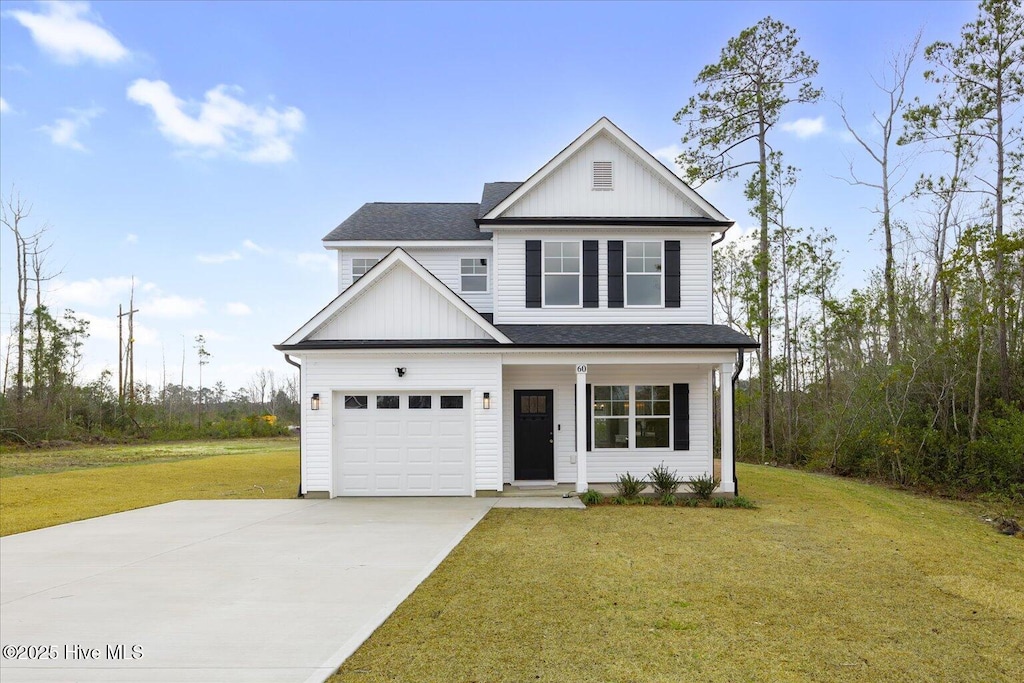 view of front of house with an attached garage, driveway, board and batten siding, and a front yard