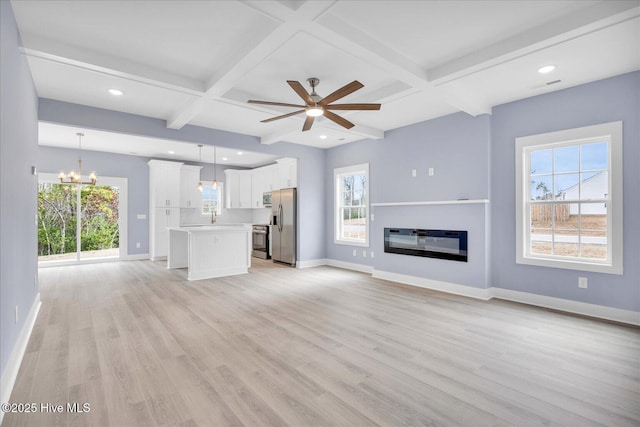 unfurnished living room with coffered ceiling, plenty of natural light, and light wood-type flooring