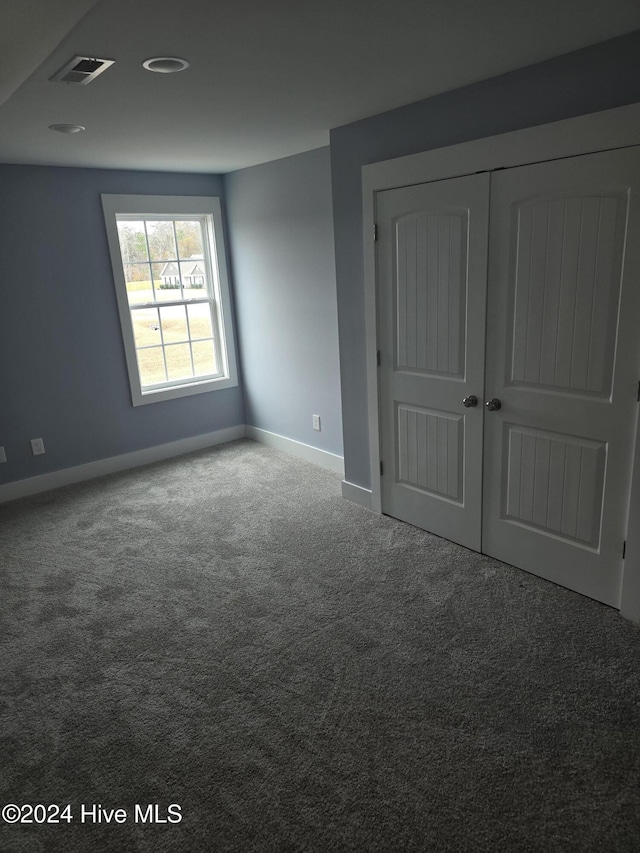 unfurnished bedroom featuring carpet floors and a closet