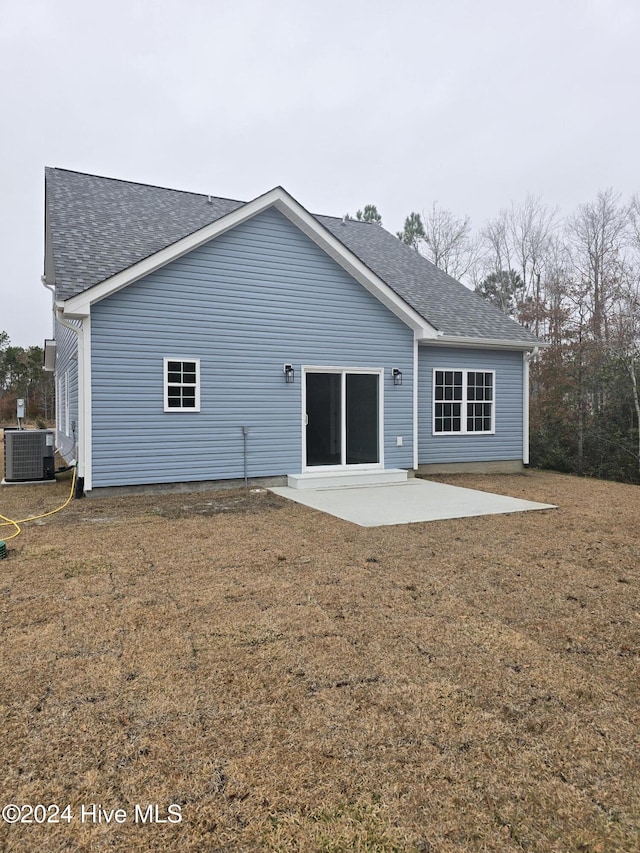 back of property with a lawn, cooling unit, and a patio