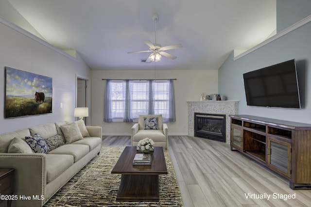 living room featuring ceiling fan, light hardwood / wood-style flooring, and lofted ceiling