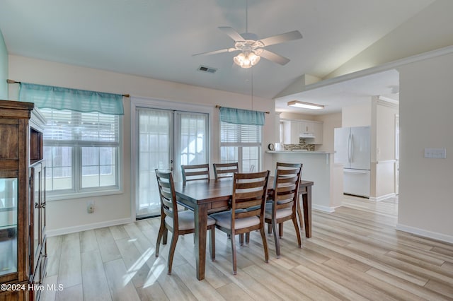 dining space featuring ceiling fan, light hardwood / wood-style flooring, and vaulted ceiling