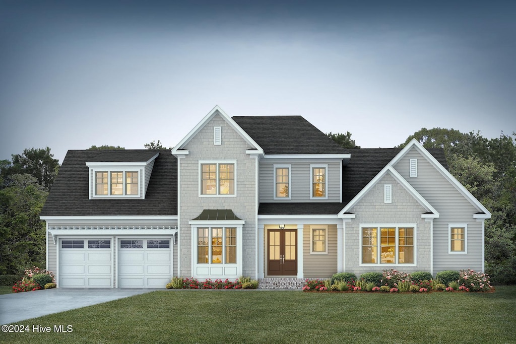 view of front of house featuring a garage and a front lawn