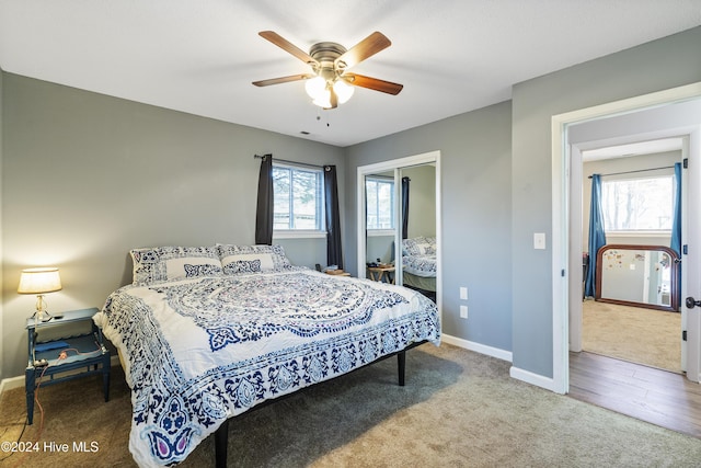 bedroom featuring hardwood / wood-style floors, ceiling fan, and multiple windows