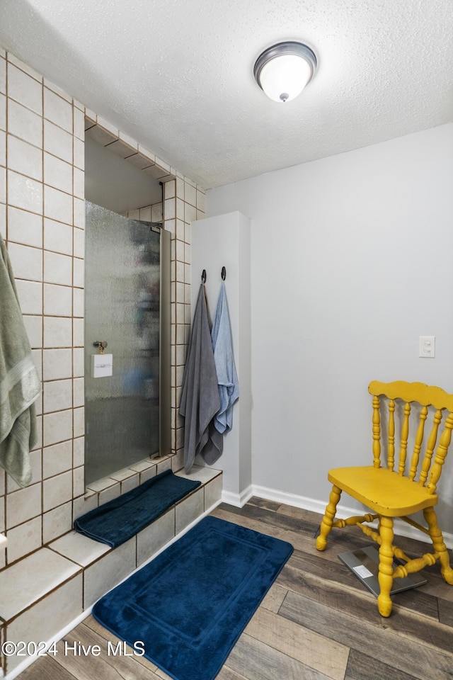 bathroom with hardwood / wood-style floors and a textured ceiling