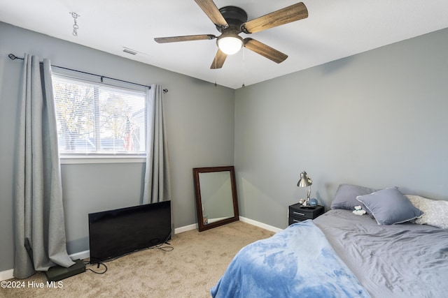 bedroom with ceiling fan and light carpet