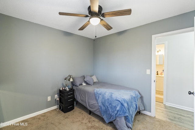 bedroom featuring ensuite bathroom, light hardwood / wood-style flooring, and ceiling fan