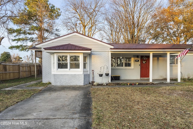 bungalow-style home with a front lawn, a porch, and a carport