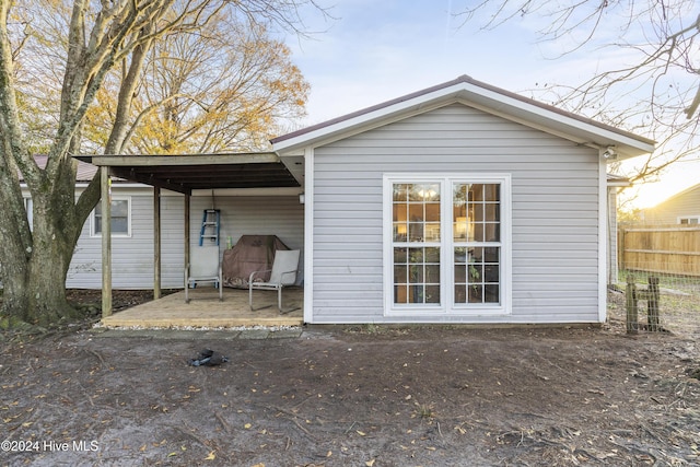 back of house featuring a carport