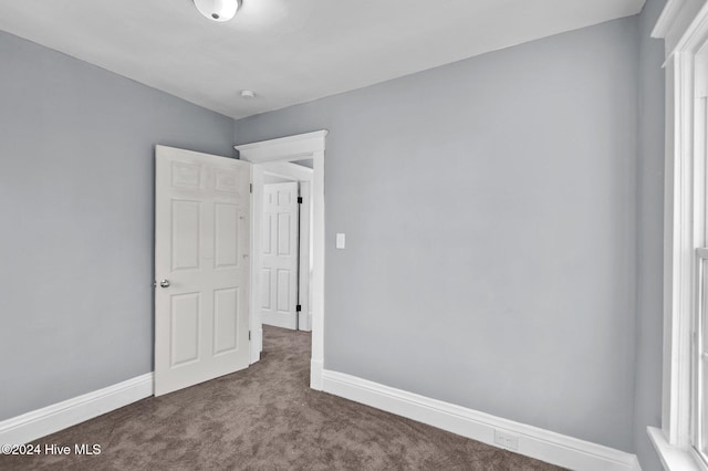 unfurnished bedroom featuring dark colored carpet