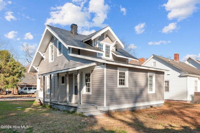 rear view of property featuring a porch and a yard